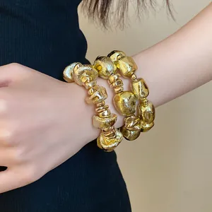 Close-up detail showing the vintage irregular gold geometric beaded bracelet on a wrist
