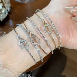 Primer plano de pulseras de corazón con circonitas en acabados oro rosa y plata.