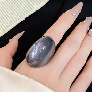 Close-up of a large oval iridescent resin ring with shimmering purple and silver bands