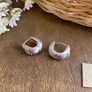 Elegant minimalist silver starburst textured hoop earrings with sparkling zircon accents.