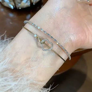 Vista detallada de una elegante pulsera de doble capa de oro rosa con un brillante corazón de circonio