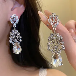 Elegant silver-toned earrings featuring intricate flower designs and crystal teardrops