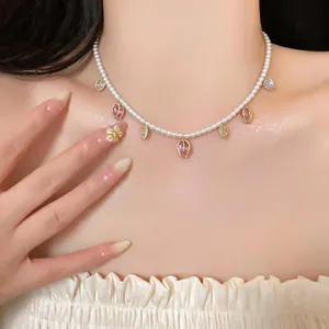 Gros plan détaillé d'un collier de perles élégant avec des pendentifs tulipes en zircon rose