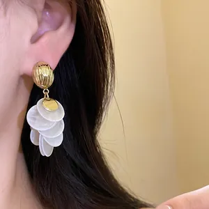 Detailed view of 14k gold plated earrings featuring elegant white shell disc fringe