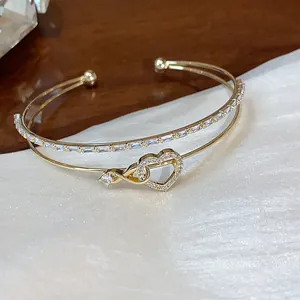 Primer plano de pulsera de doble capa con colgante de corazón y detalles de circón.