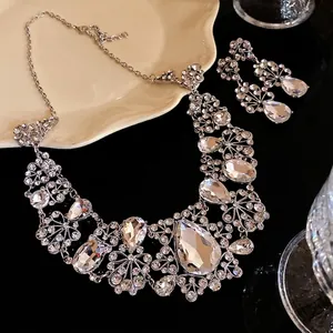 Elegant silver-toned necklace and earrings set with floral teardrop crystals