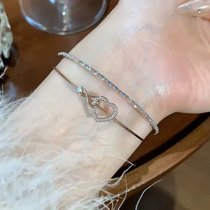 Detalle macro de una elegante pulsera de corazón de oro rosa con piedras de circonita