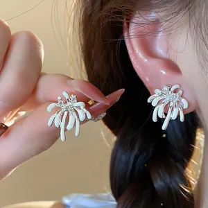 Close-up detail of white firework-shaped stud earrings with sparkling zircon center