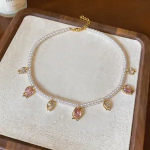 Vue détaillée du collier de perles avec pendentifs tulipe en zircon rose sur plateau
