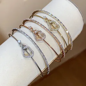 Primer plano de pulseras de doble capa con corazón e infinito y circonitas brillantes.