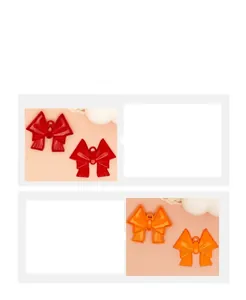 Detail view of colorful spray-painted alloy bow pendants for DIY accessory crafts