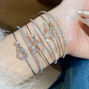 Primer plano de elegantes brazaletes de corazón con brillantes circonitas cúbicas