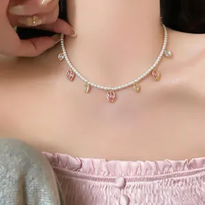 Gros plan d'un collier de perles élégant avec des pendentifs tulipes en zircon rose