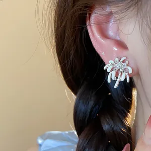 Detailed close-up showing a white enamel firework stud earring with zircon on ear