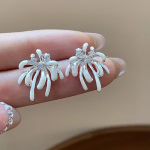 Detailed macro view of elegant zircon firework stud earrings with white enamel finish