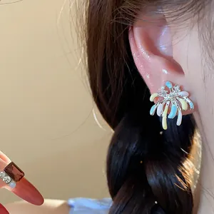 Detailed close-up view of colorful drip oil enamel firework stud earrings worn on model ear