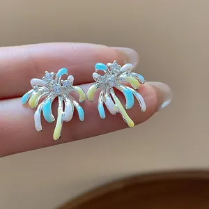 Macro view of fireworks stud earrings featuring colorful enamel drips and zircons.