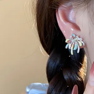 Close-up detail of colorful enamel firework stud earrings decorated with sparkling zircon