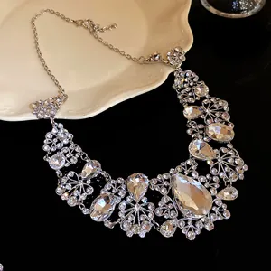 Detail showing intricate floral patterns and pear-cut rhinestones on a silver necklace.