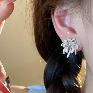 Detailed close-up showing a white oil-drop firework stud earring with sparkling zircons on ear