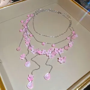 Elegante mehrlagige rosa Perlenkette mit süßen Blumenanhängern und Tropfenanhängern