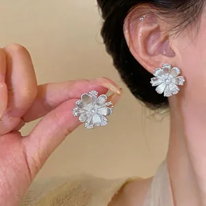 Elegant silver-tone flower stud earrings with shimmering cubic zirconia for women.