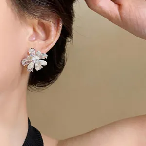 Close-up view of elegant silver flower stud earring with sparkling zircon petals.