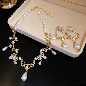 Detail view of vintage pearl and rhinestone necklace and earring set with teardrop pendants