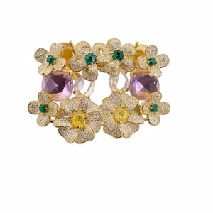 Luxueuses boucles d'oreilles fleurs dorées avec zircons et pierres violettes