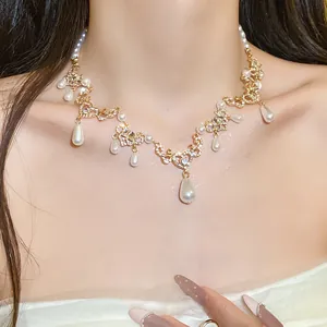 Close-up of elegant vintage pearl necklace with teardrop pendants and rhinestone details.