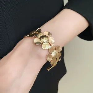 Eleganter goldener Blumen-Armreif mit strukturierten Blütenblättern am Handgelenk