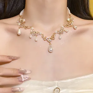 Close-up of a vintage pearl necklace with a rhinestone heart and teardrop pendants