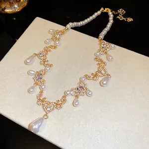 Close-up detail of the crystal heart filigree and waterdrop pearl pendants on the necklace.