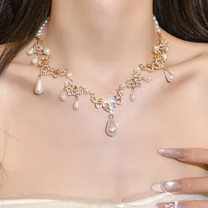 Detailed view of a vintage pearl necklace with rhinestone water drop pendants on model