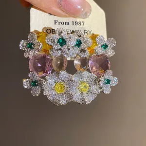 Vue détaillée de boucles d'oreilles fleurs en zircon de luxe avec pierres roses et jaunes