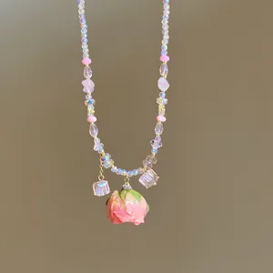 Close-up of sweet style beaded necklace with a preserved pink rose pendant detail