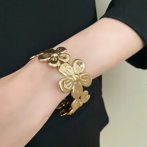 Nahaufnahme eines goldenen Metallarmbands im Vintage-Stil mit Blumenmuster für Damen.