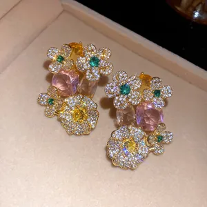 Gros plan détaillé de boucles d'oreilles fleuries avec pierres roses et ambrées