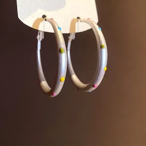Elegant silver hoop earrings with vibrant colorful polka dots for a minimalist style.