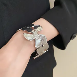 Detailansicht eines schicken silberfarbenen floralen Armreifs an einem Handgelenk