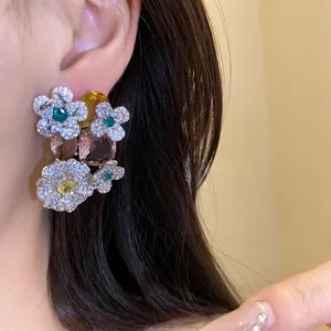 Gros plan de boucles d'oreilles fleurs en argent avec zircone et pierres colorées