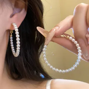 Close-up view of French retro pearl beaded hoop earrings showing elegant jewelry texture