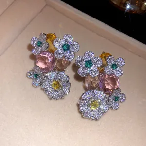 Gros plan de boucles d'oreilles fleurs avec des zircons colorés dans un écrin à bijoux