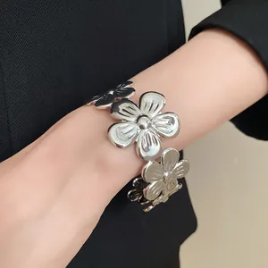 Detailansicht eines vintage silbernen Metallblumen-Armreifs am Handgelenk einer Frau