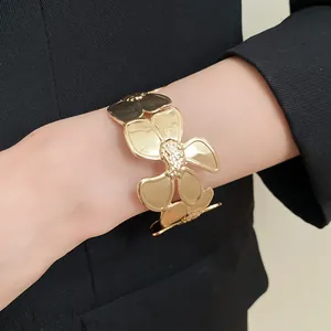 Nahaufnahme eines goldenen Metallarmbands mit Blumenmuster im Vintage-Stil am Handgelenk