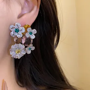 Gros plan de boucles d'oreilles fleurs en argent avec zircons multicolores et élégants