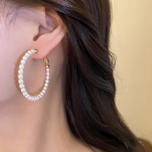 Close-up detail of elegant pearl beaded hoop earrings in a vintage French style.