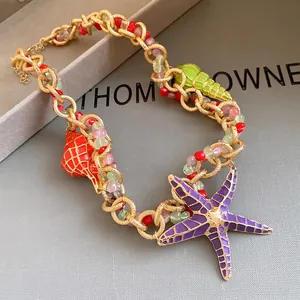 Close-up detail of vintage beaded necklace with enamel starfish and sea shell charms