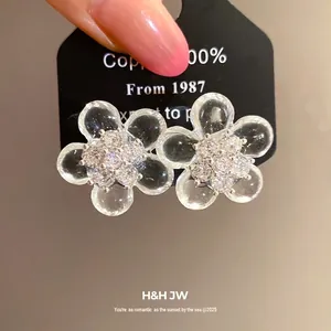 Elegant clear resin flower stud earrings with a sparkling cubic zirconia center cluster