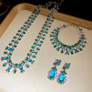 Detailansicht eines Vintage-Schmucksets mit blauen und grünen Zirkonen auf einem Goldtablett